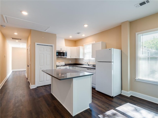 689 Berne St SE, Atlanta, GA 30312 - kitchen with white appliances, a kitchen island, white cabinets, plenty of natural light, and recessed lighting