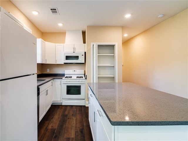 689 Berne St SE, Atlanta, GA 30312 - kitchen featuring white appliances, dark wood-style flooring, white cabinetry, dark stone counters, and recessed lighting