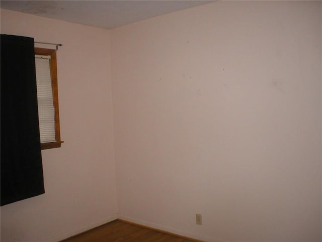 unfurnished room with dark hardwood / wood-style flooring