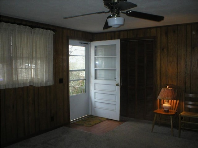 entryway featuring ceiling fan and wooden walls