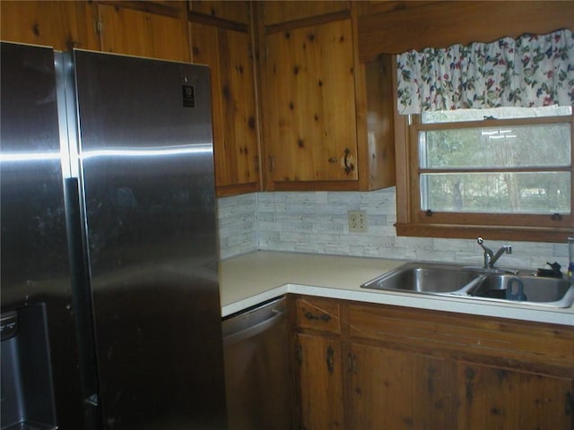 kitchen featuring decorative backsplash, sink, stainless steel dishwasher, and black fridge with ice dispenser