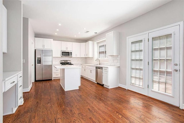 4609 Mctyre Way, Marietta, GA 30064 - kitchen with white cabinets, a center island, backsplash, and appliances with stainless steel finishes