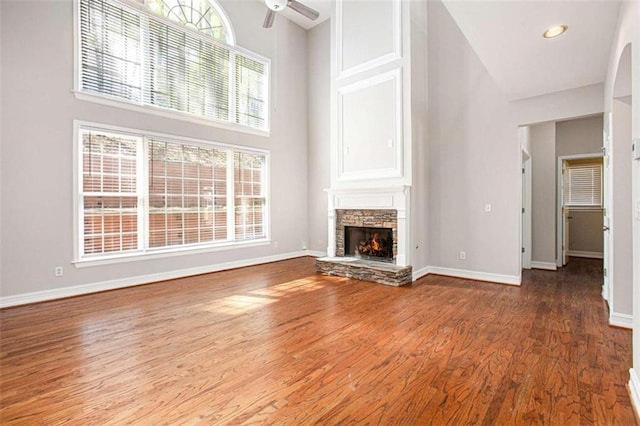 4609 Mctyre Way, Marietta, GA 30064 - unfurnished living room featuring baseboards, a stone fireplace, ceiling fan, a towering ceiling, and wood finished floors