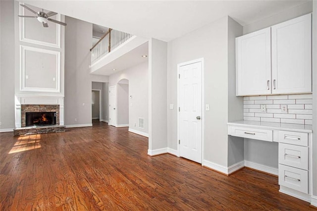 4609 Mctyre Way, Marietta, GA 30064 - unfurnished living room featuring baseboards, built in desk, dark wood-style flooring, a ceiling fan, and a fireplace