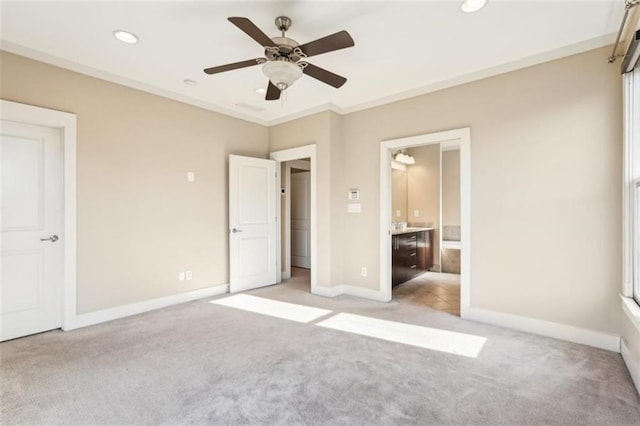 unfurnished bedroom with light carpet, ensuite bathroom, and baseboards