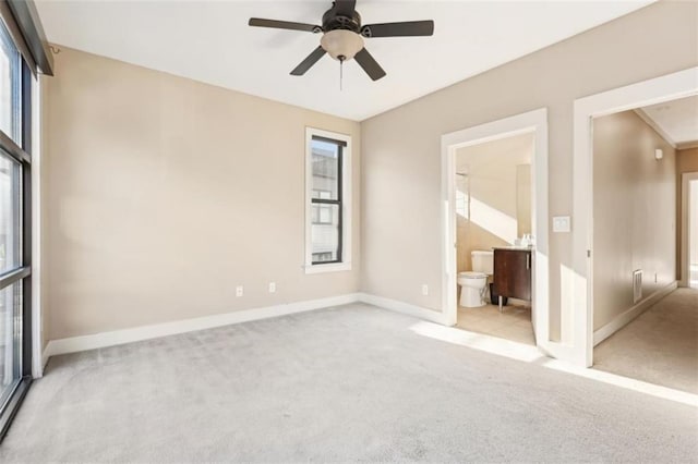 unfurnished bedroom with a ceiling fan, carpet, baseboards, and connected bathroom