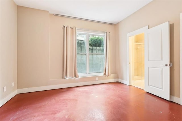 unfurnished room with baseboards and finished concrete floors