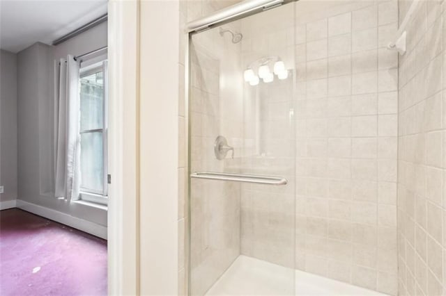 bathroom featuring a shower stall and baseboards