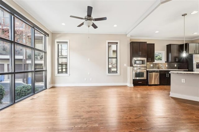 kitchen with tasteful backsplash, plenty of natural light, appliances with stainless steel finishes, and ceiling fan