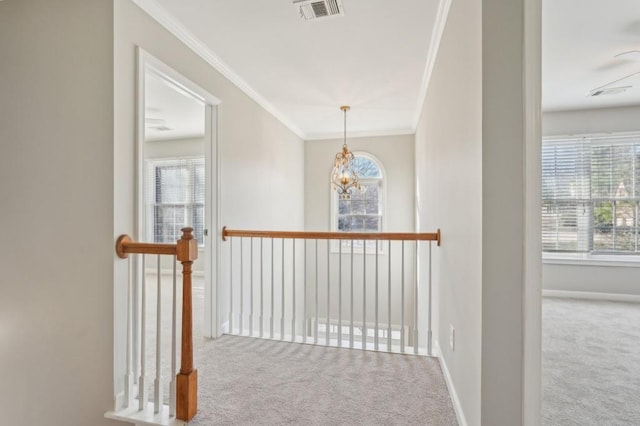 corridor with carpet floors, ornamental molding, visible vents, and baseboards