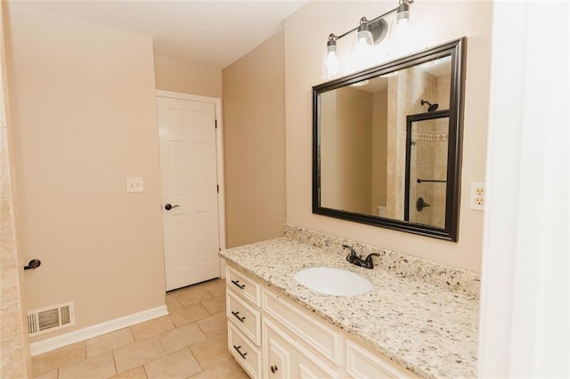 bathroom with vanity, a tile shower, and tile patterned flooring