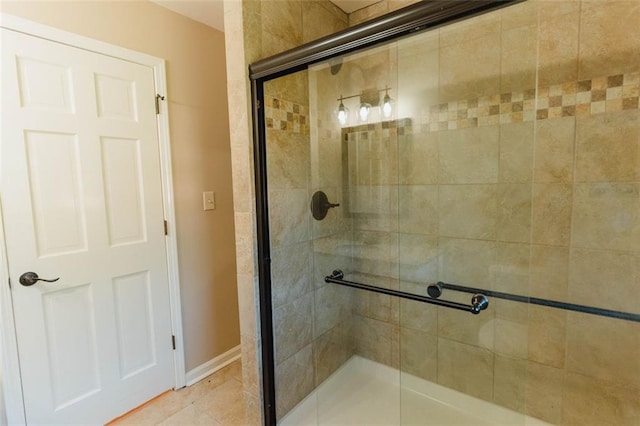 bathroom featuring a shower with shower door and tile patterned floors