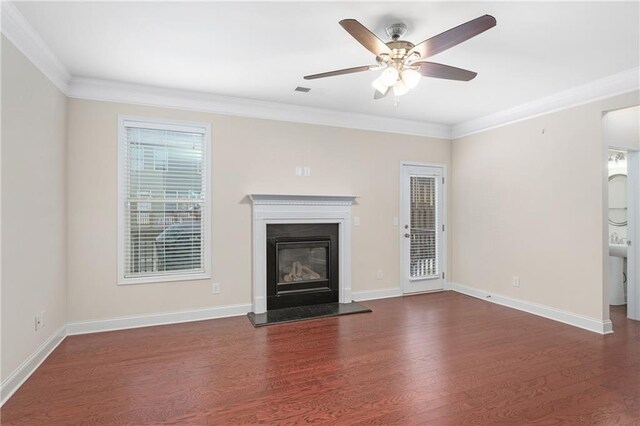 unfurnished living room featuring ceiling fan, dark wood-type flooring, and crown molding