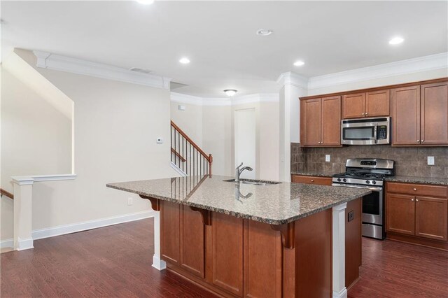 kitchen featuring dark hardwood / wood-style floors, sink, stainless steel appliances, and a center island with sink