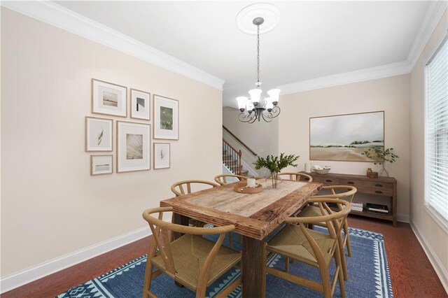 dining space featuring dark hardwood / wood-style flooring, ornamental molding, and a notable chandelier