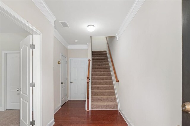 staircase featuring ornamental molding and hardwood / wood-style flooring