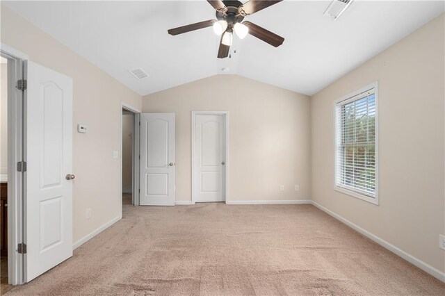 unfurnished bedroom featuring ceiling fan, light colored carpet, and lofted ceiling