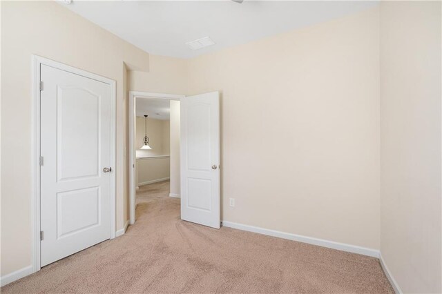 unfurnished room featuring light colored carpet