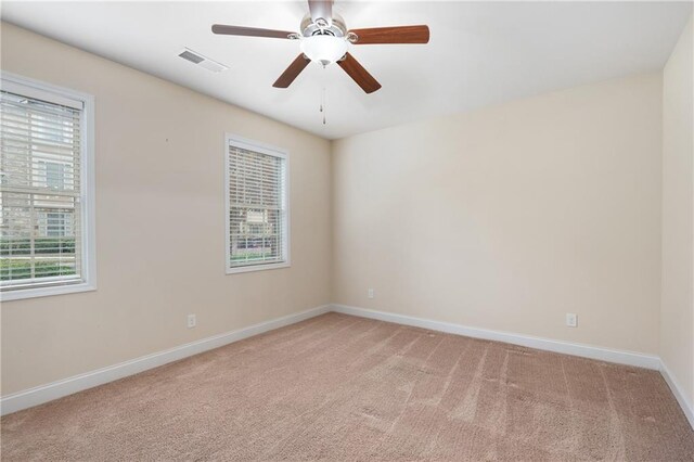 carpeted spare room with ceiling fan