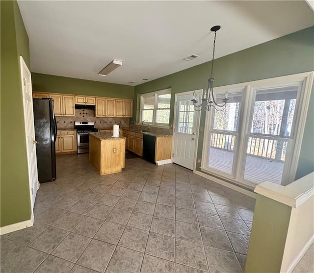 kitchen featuring a chandelier, a sink, backsplash, a center island, and black appliances