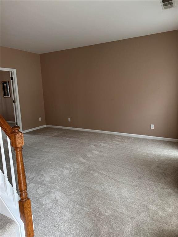 spare room featuring baseboards, visible vents, stairway, and carpet flooring