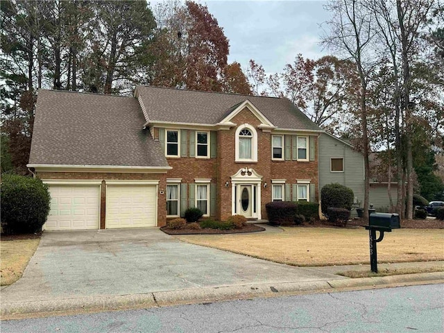 colonial-style house featuring a garage, concrete driveway, a front lawn, and brick siding