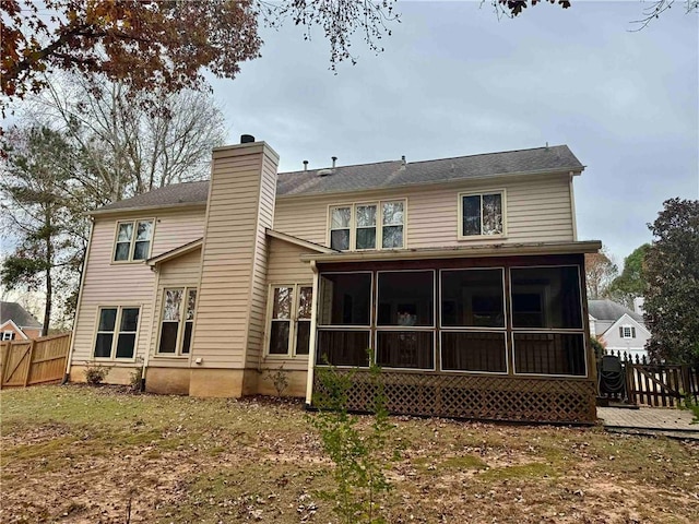 back of house featuring a sunroom and a wooden deck