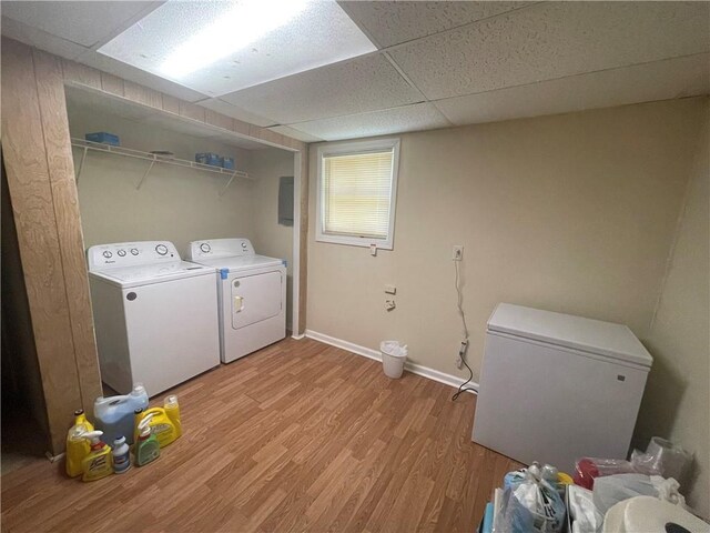 laundry room with washing machine and dryer and light hardwood / wood-style flooring