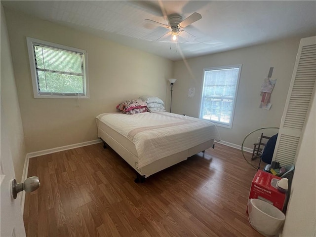 bedroom with ceiling fan, multiple windows, and wood-type flooring