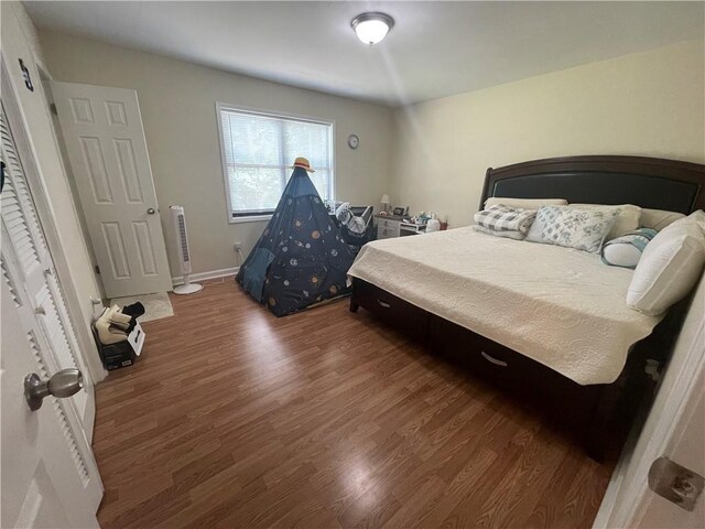 bedroom with dark hardwood / wood-style floors