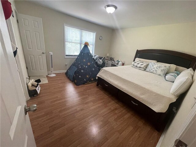 bedroom with dark hardwood / wood-style flooring