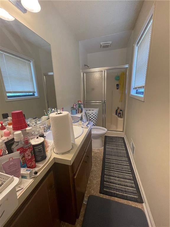 bathroom with a shower with door, tile flooring, vanity, and toilet