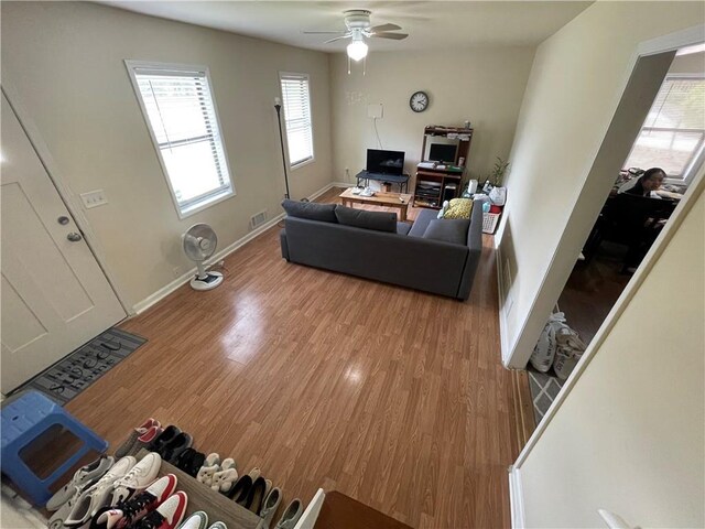 living room featuring ceiling fan and hardwood / wood-style floors