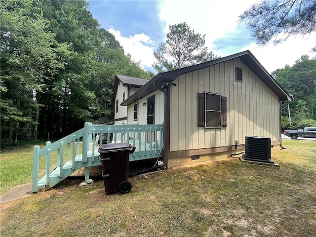 view of property exterior with a wooden deck, a yard, and central AC unit