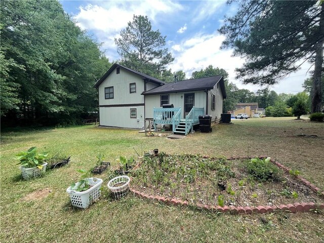 rear view of property featuring a yard and a deck