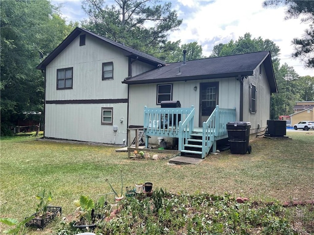 rear view of property with a yard and central air condition unit