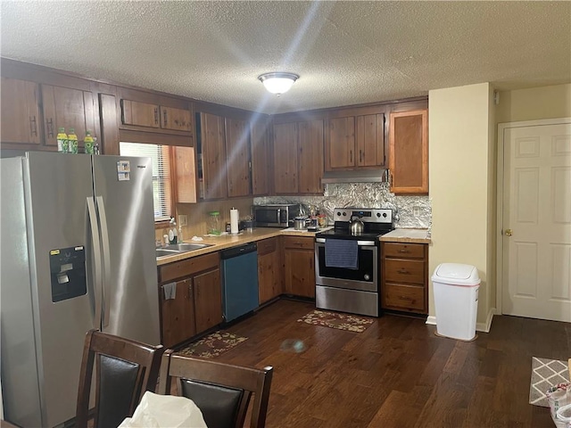 kitchen featuring dark hardwood / wood-style floors, tasteful backsplash, appliances with stainless steel finishes, sink, and a textured ceiling