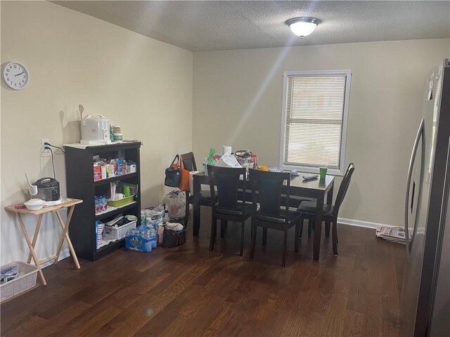 dining room featuring dark hardwood / wood-style flooring and a textured ceiling