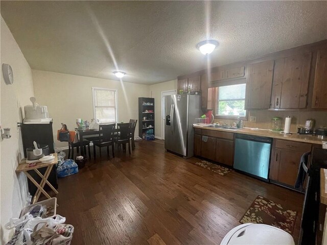 kitchen featuring stainless steel appliances, dark hardwood / wood-style flooring, and a textured ceiling