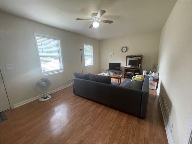 living room with wood-type flooring and ceiling fan