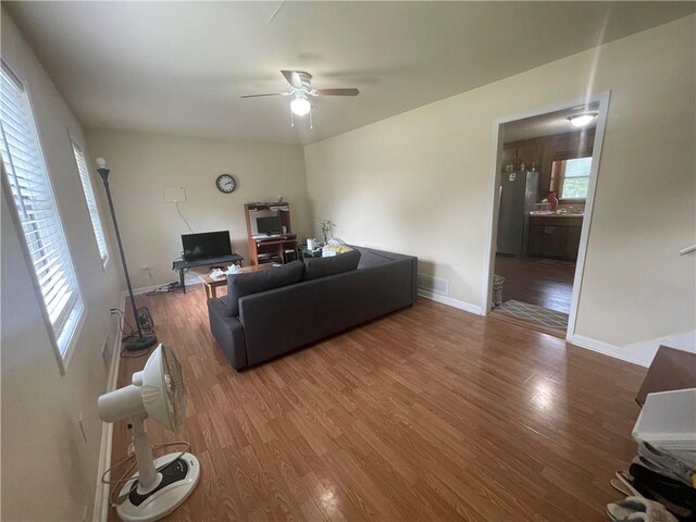 living room featuring a wealth of natural light, dark wood-type flooring, and ceiling fan