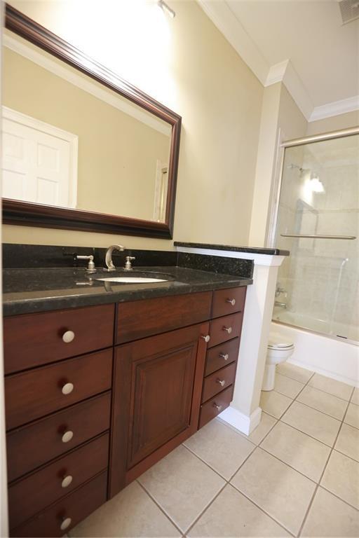 3541 Roswell Rd NE Unit 20, Atlanta, GA 30305 - bathroom with ornamental molding, tile patterned floors, vanity, toilet, and shower / bathtub combination