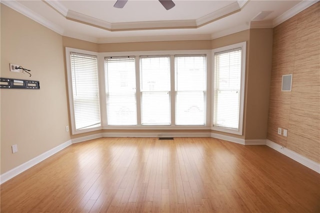 3541 Roswell Rd NE Unit 20, Atlanta, GA 30305 - spare room with ornamental molding, a tray ceiling, a ceiling fan, baseboards, and light wood finished floors