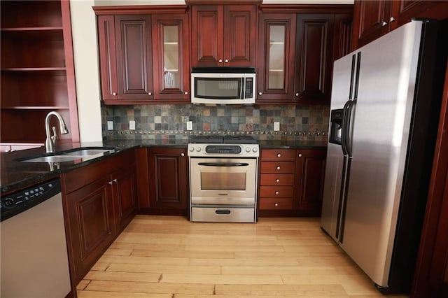 3541 Roswell Rd NE Unit 20, Atlanta, GA 30305 - kitchen with appliances with stainless steel finishes, a sink, light wood-style floors, backsplash, and reddish brown cabinets