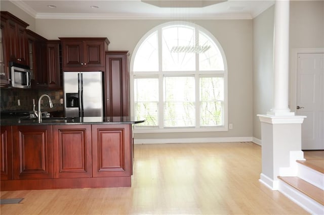 3541 Roswell Rd NE Unit 20, Atlanta, GA 30305 - kitchen featuring appliances with stainless steel finishes, ornate columns, dark countertops, a sink, and light wood-type flooring