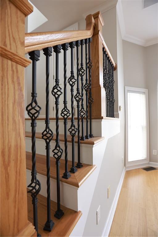 3541 Roswell Rd NE Unit 20, Atlanta, GA 30305 - staircase featuring baseboards, wood finished floors, and ornamental molding