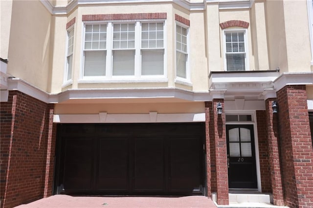 3541 Roswell Rd NE Unit 20, Atlanta, GA 30305 - doorway to property featuring stucco siding, brick siding, a garage, and driveway
