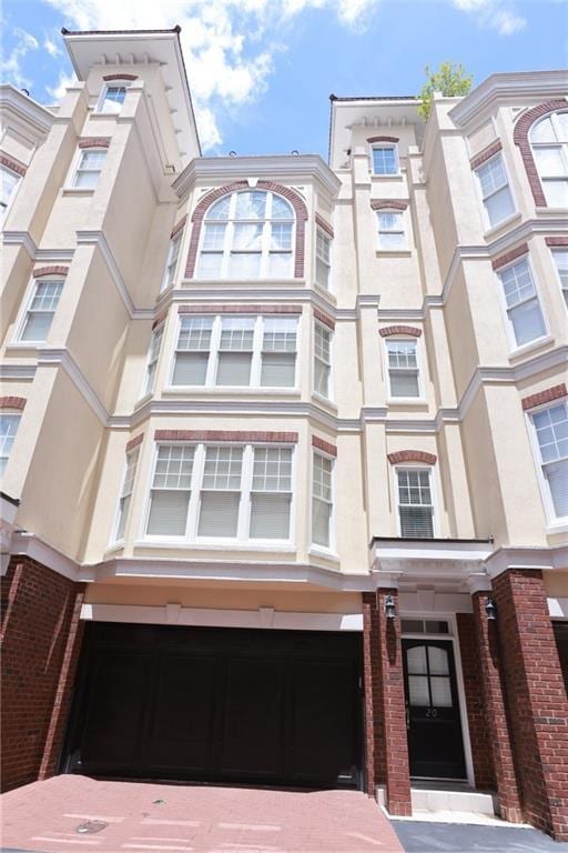 3541 Roswell Rd NE Unit 20, Atlanta, GA 30305 - view of building exterior with an attached garage and driveway