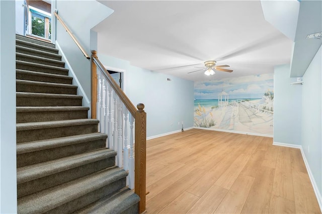 1920 Jett Ridge Rd, Cumming, GA 30041 - stairs with baseboards, wood finished floors, an accent wall, a ceiling fan, and wallpapered walls