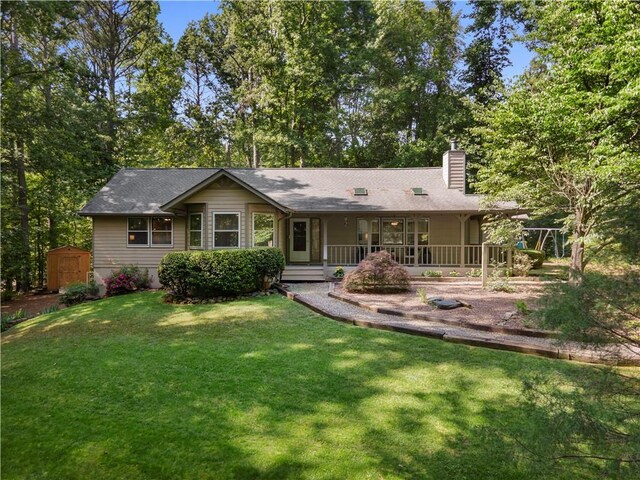 1920 Jett Ridge Rd, Cumming, GA 30041 - view of front of home featuring a storage unit, a chimney, covered porch, a front yard, and an outbuilding